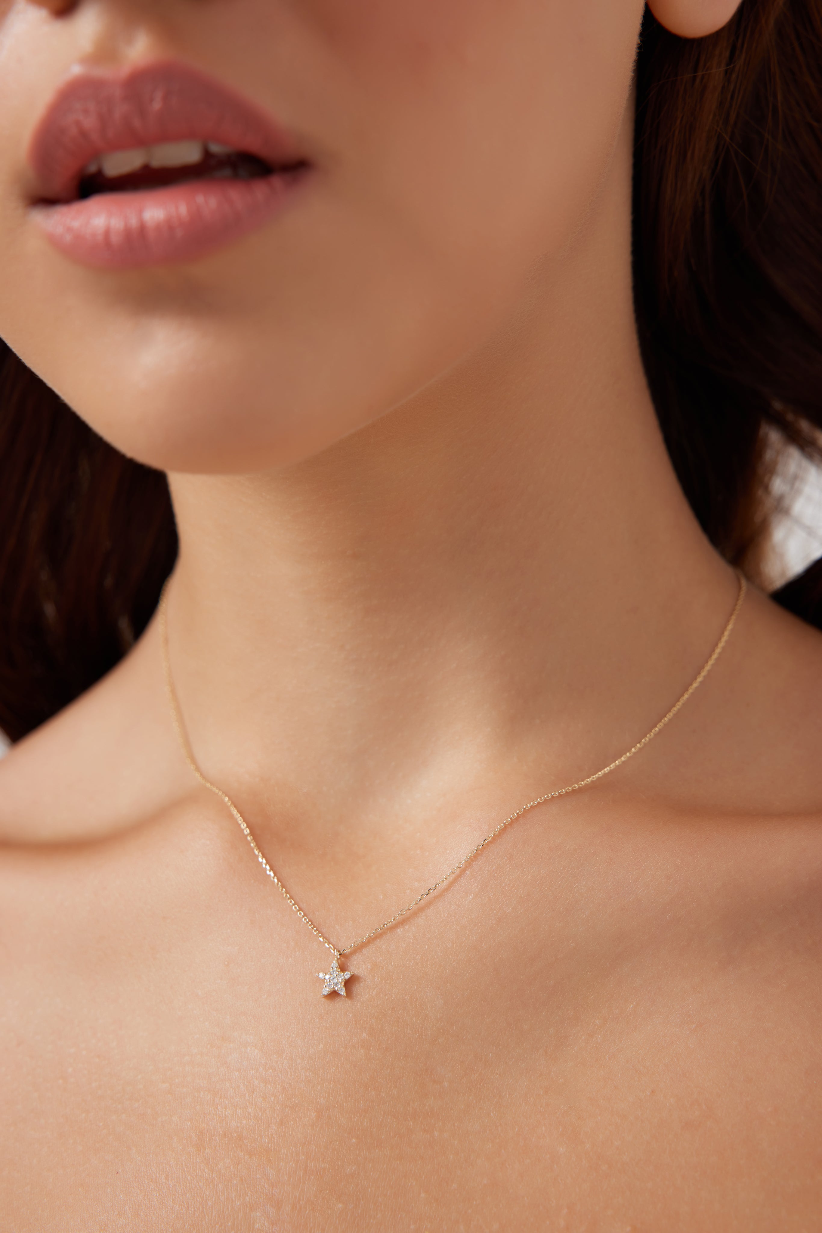 Model wearing a 14K solid yellow gold diamond star necklace, showcasing its dainty minimalist design.