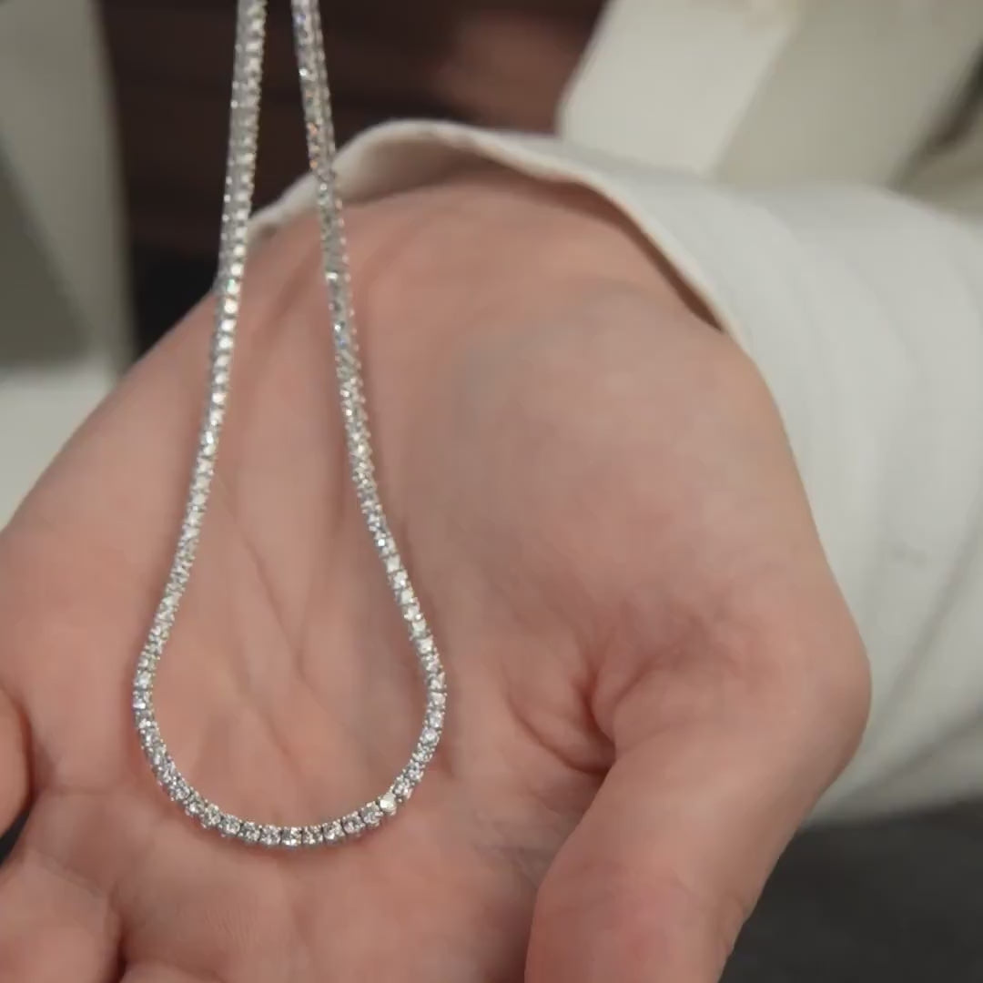 14K solid white gold diamond tennis necklace in a hand, showcasing its sparkle and elegance.