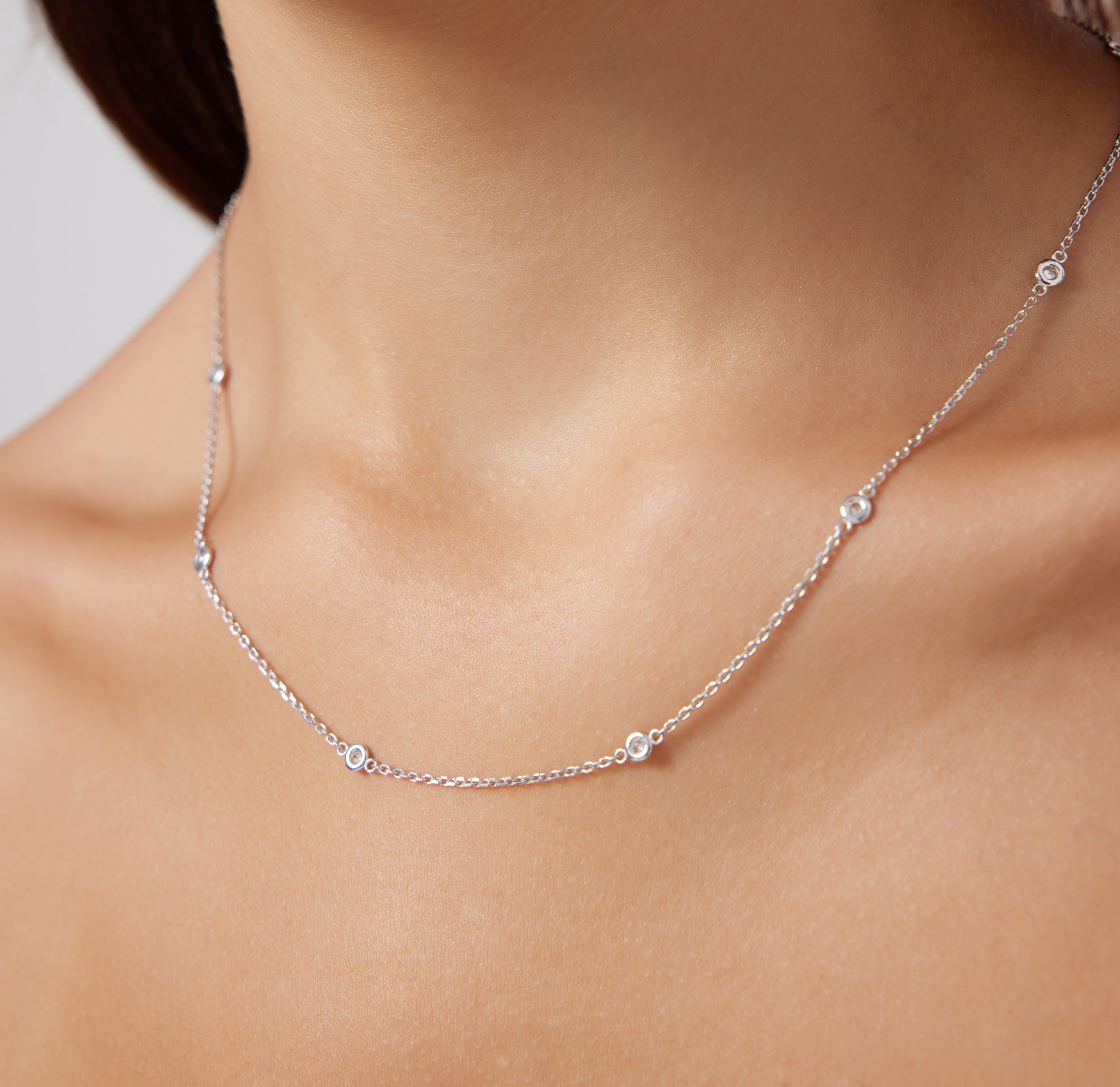 14K Gold Diamond Station Necklace on model, featuring delicate bezel-set diamonds, perfect for everyday elegance.