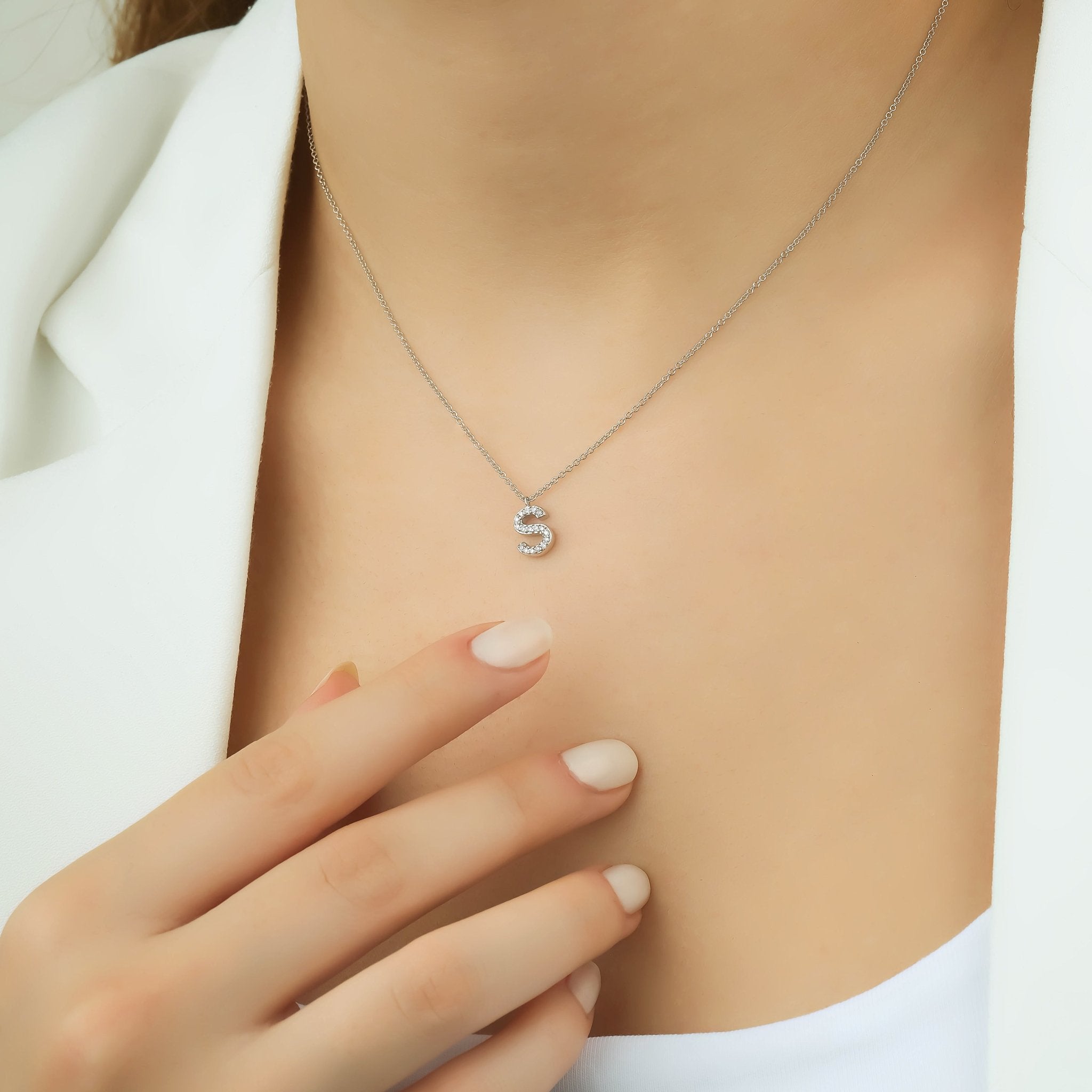 14K white gold letter S initial necklace with diamonds, worn close-up on a woman, showcasing elegance and sparkle.