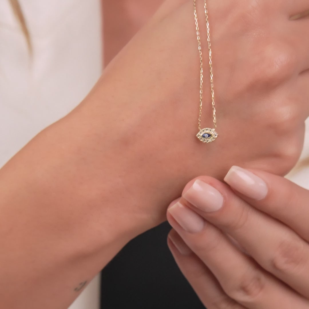 Dainty 14K solid yellow gold minimalist evil eye necklace worn on a hand, highlighting its elegance and craftsmanship.