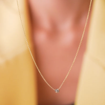 Dainty minimalist 14K solid white gold necklace with bezel-set diamond pendant, perfect for everyday wear.