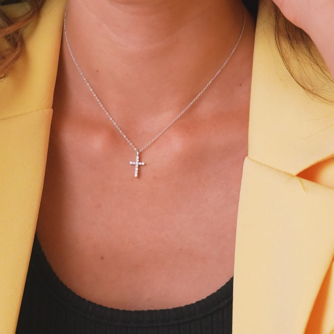 Dainty 14K solid white gold diamond cross necklace worn by a model, showcasing its minimalist design and elegance.