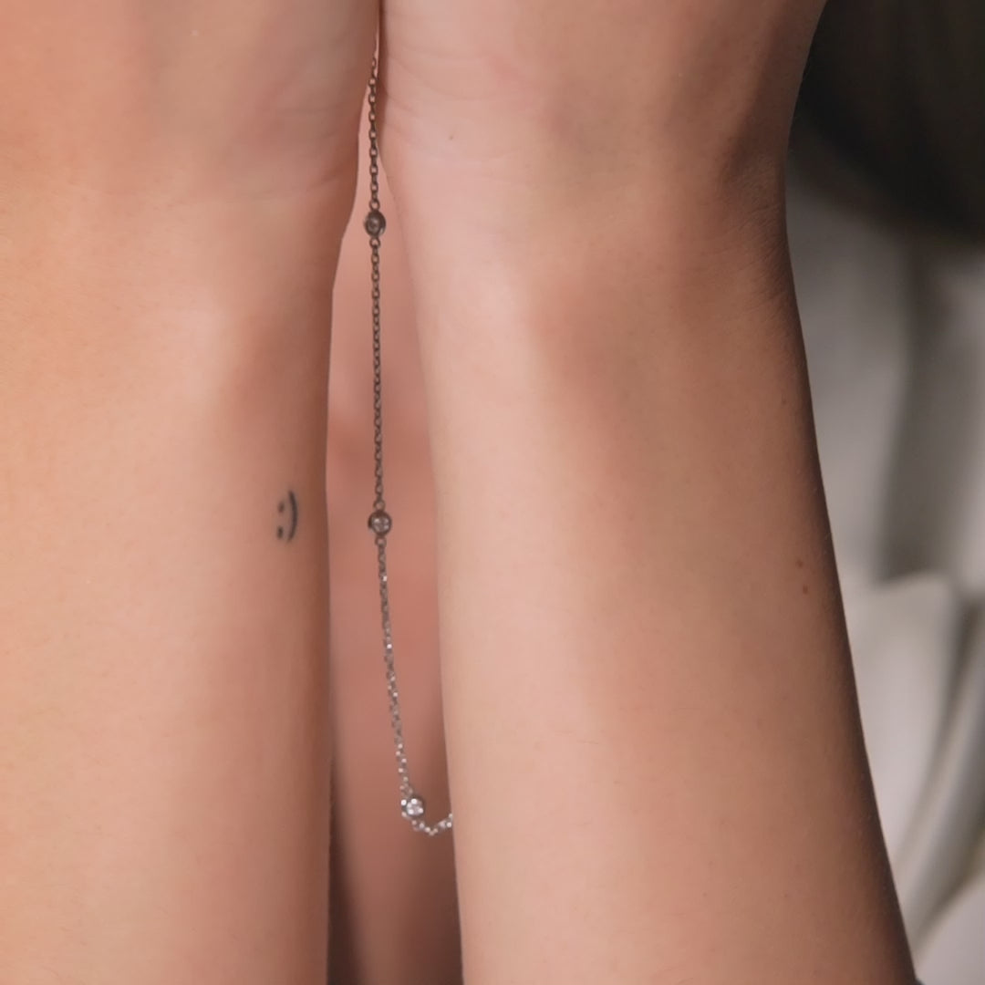 Dainty 14K Gold Diamond Station Necklace showcased on hands, featuring bezel-set diamonds and simple design.