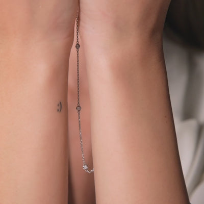 Dainty 14K Gold Diamond Station Necklace showcased on hands, featuring bezel-set diamonds and simple design.