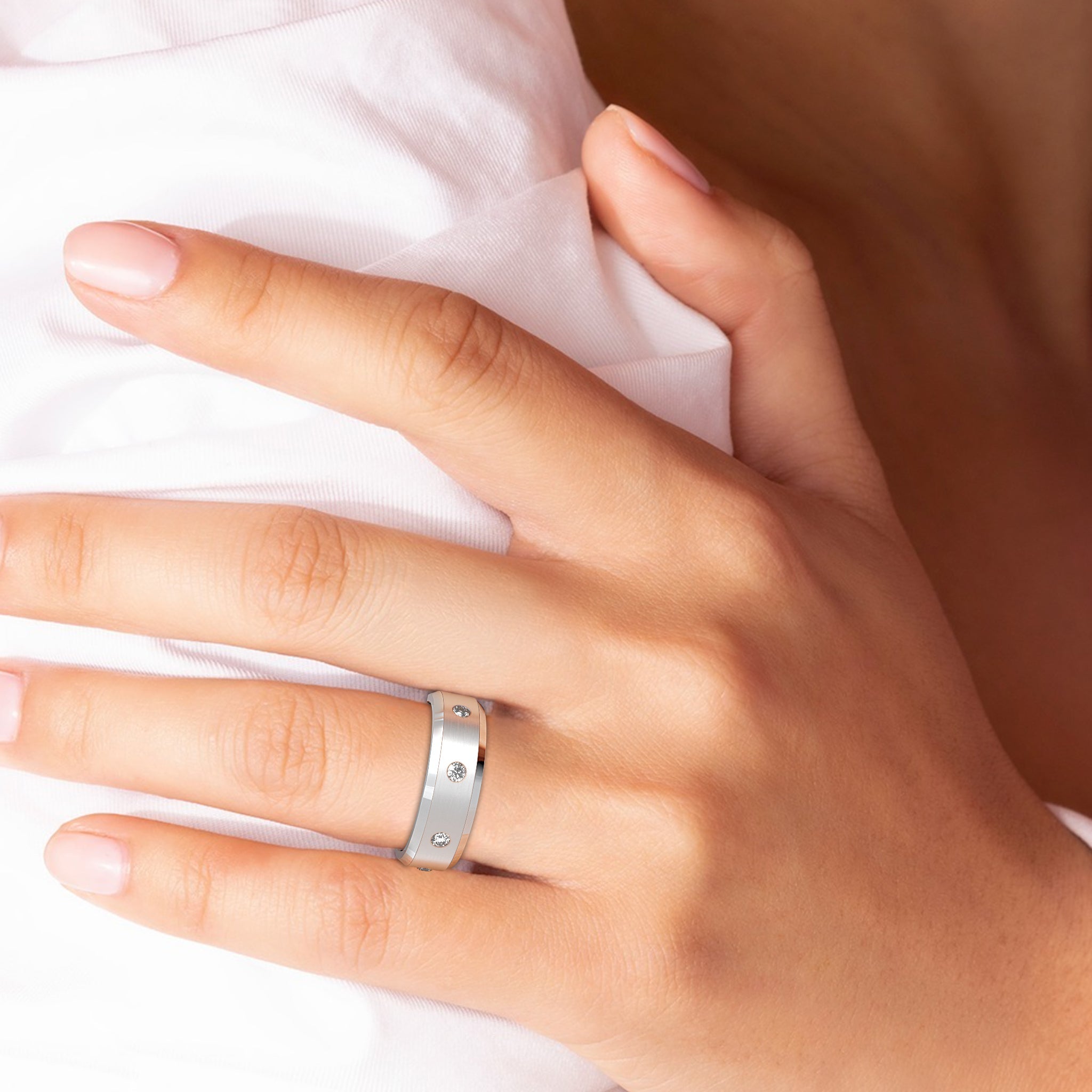 Platinum flat diamond men's wedding band worn on hand, showcasing brushed finish and round brilliant cut diamonds.